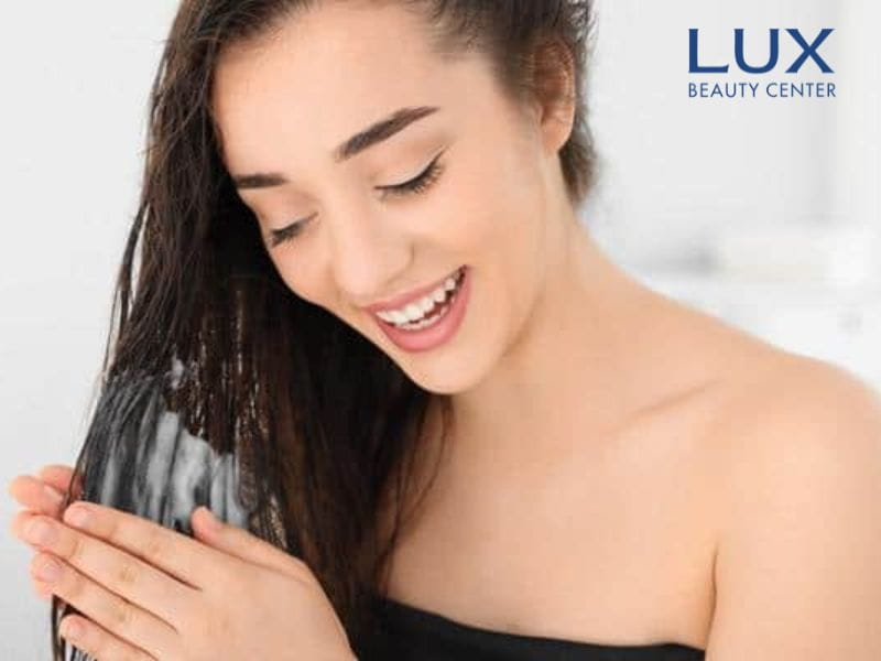 cô gái đang xả tóc bằng dầu xả